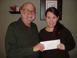 Mike Repinski (right) of CenturyLink renews the company's commitment to literacy with a donation to Literacy Partners' Mary Gotstein and Bob Garfinkel